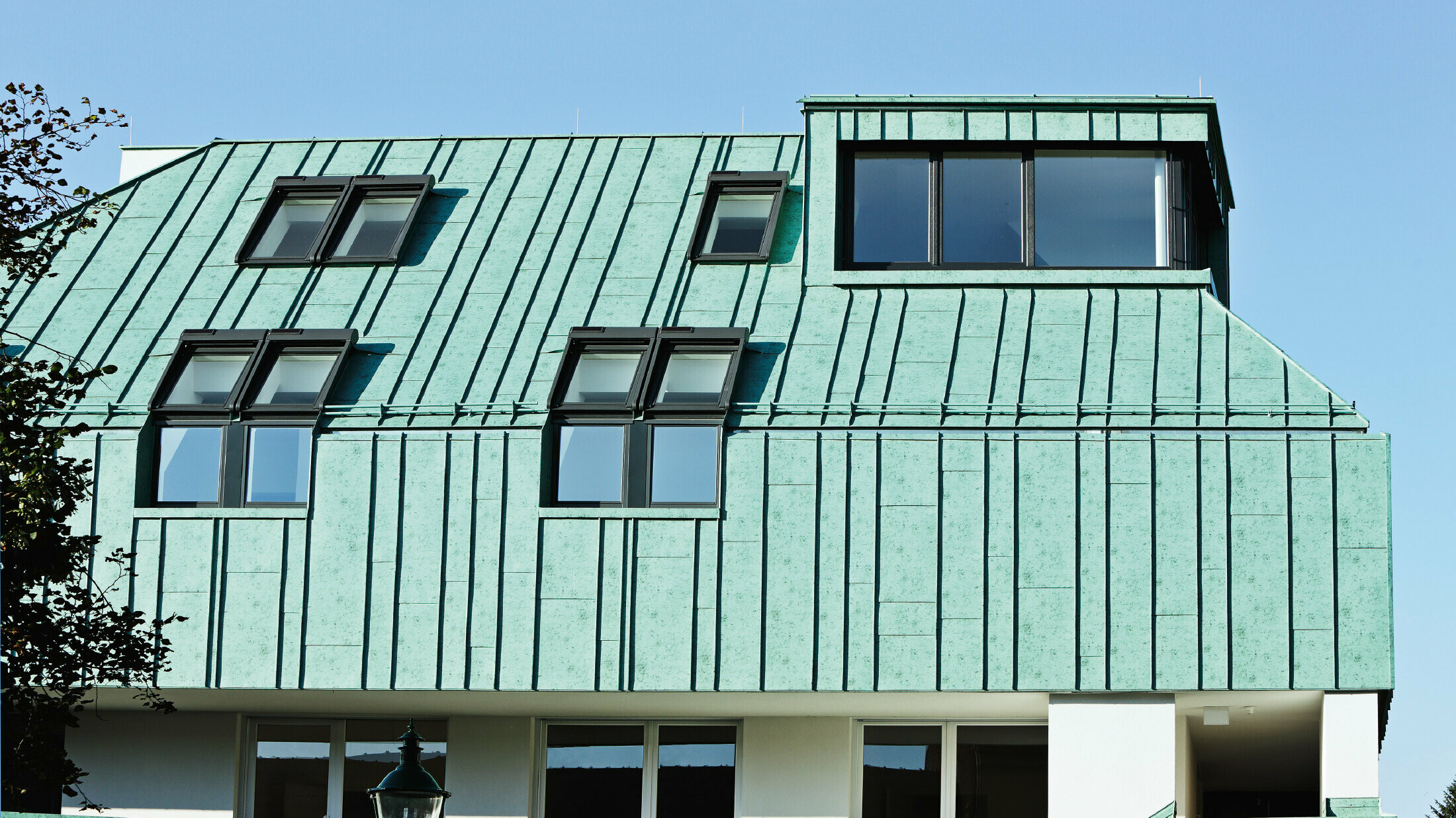 Allestimento per tetto e facciata con PREFALZ PREFA in patina verde in diverse larghezze di lastre