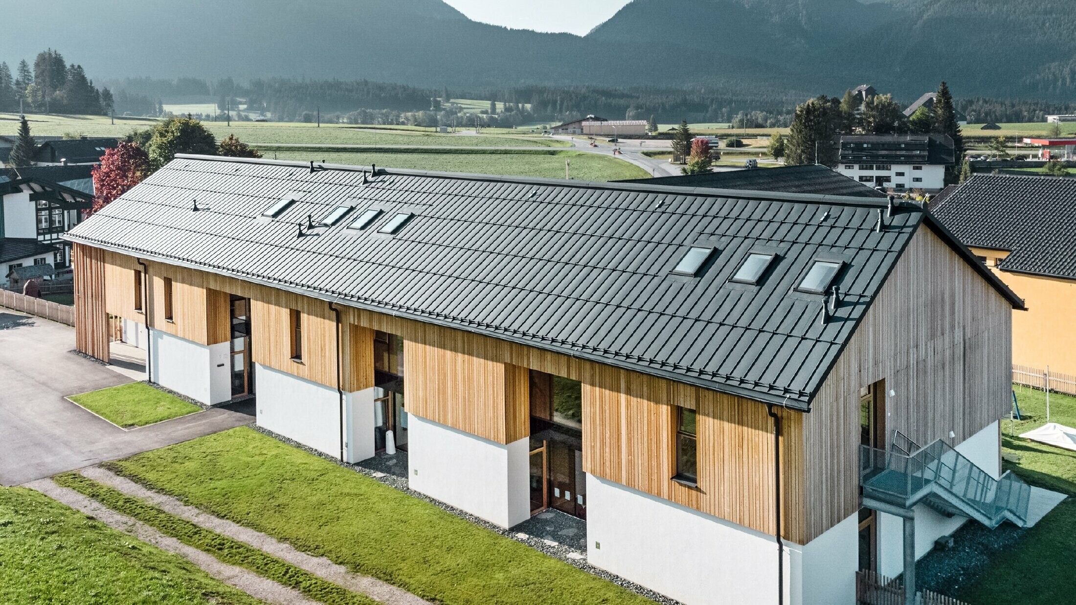 Scuola materna delle erbe a Bad Mitterndorf con grande tetto PREFALZ in P.10 antracite e facciata in legno