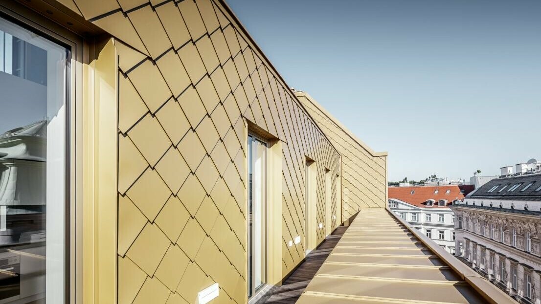 Seitliche Ansicht des Dachgeschossausbaus mit PREFA Rauten 29 × 29 in Perlgold