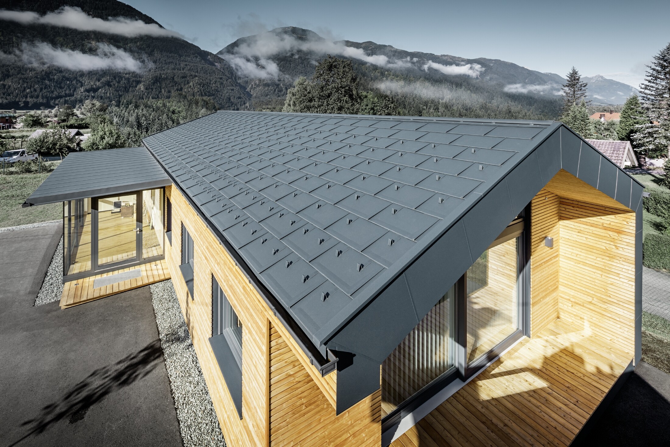 Nuovo edificio per uffici di Holzbau Faltheiner con facciata in legno di larice, ampie vetrate e tetto PREFA in antracite.
