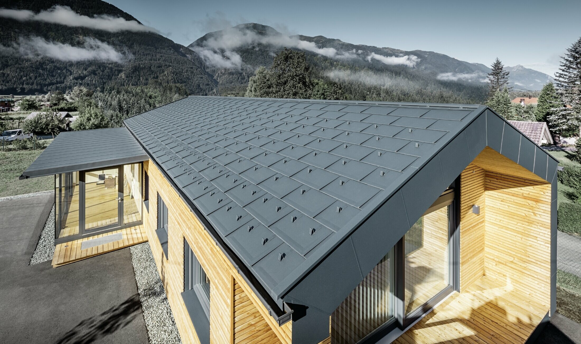 Nuovo edificio per uffici di Holzbau Faltheiner con facciata in legno di larice, ampie vetrate e tetto PREFA in antracite.