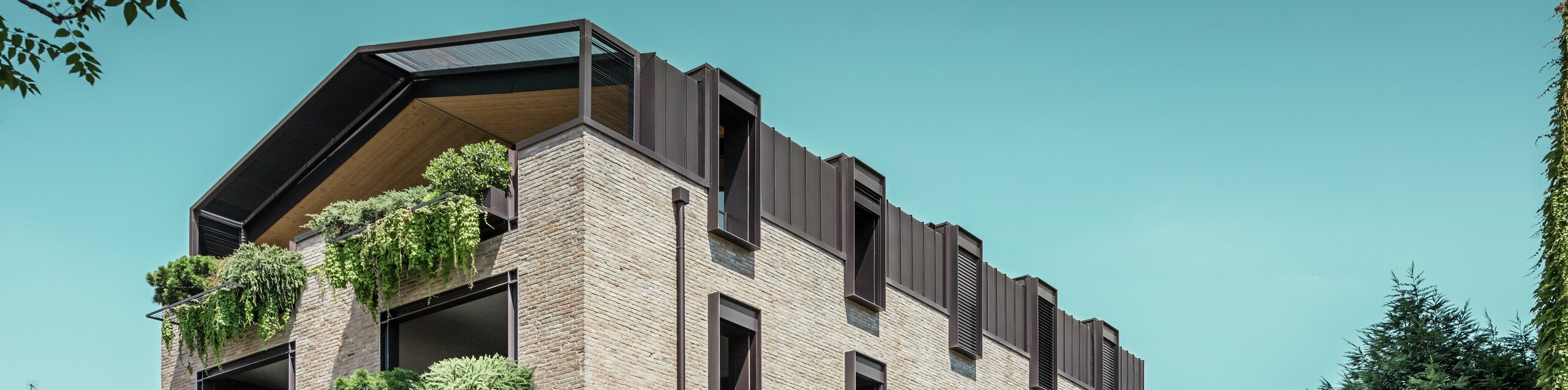 Modernes Wohngebäude in Italien mit PREFALZ Aluminiumdach in P.10 Nussbraun, Backsteinfassade und hängenden Gärten – nachhaltige Architektur für die Sanierung dieses Gebäudes.