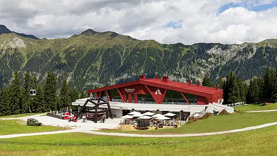 Rifugio e ristorante Summit Mountain Club in primavera circondato dai prati verdi. A 1.830 metri, vicino alla stazione a monte Rinneralm (2.100 m), il Summit Mountain Club si posiziona come nuovo punto di riferimento per gli appassionati di sport invernali e gli ospiti estivi e, sempre più, come luogo per eventi aziendali e riunioni.