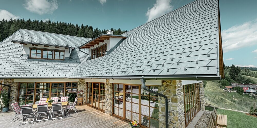 Einfamilienhaus eingedeckt mit PREFA Dachschindeln in der Farbe P.10 Steingrau