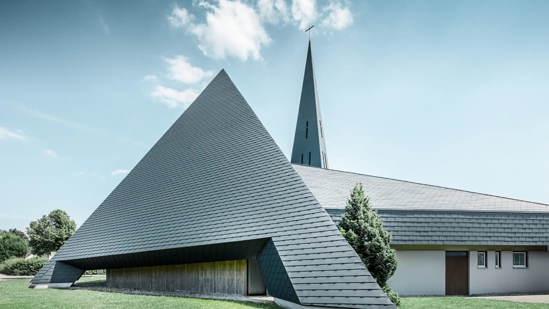 katholische Kirche in Langenau mit einem Design ähnlich einer Pyramide eingedeckt mit PREFA Aluminiumschindeln in anthrazit