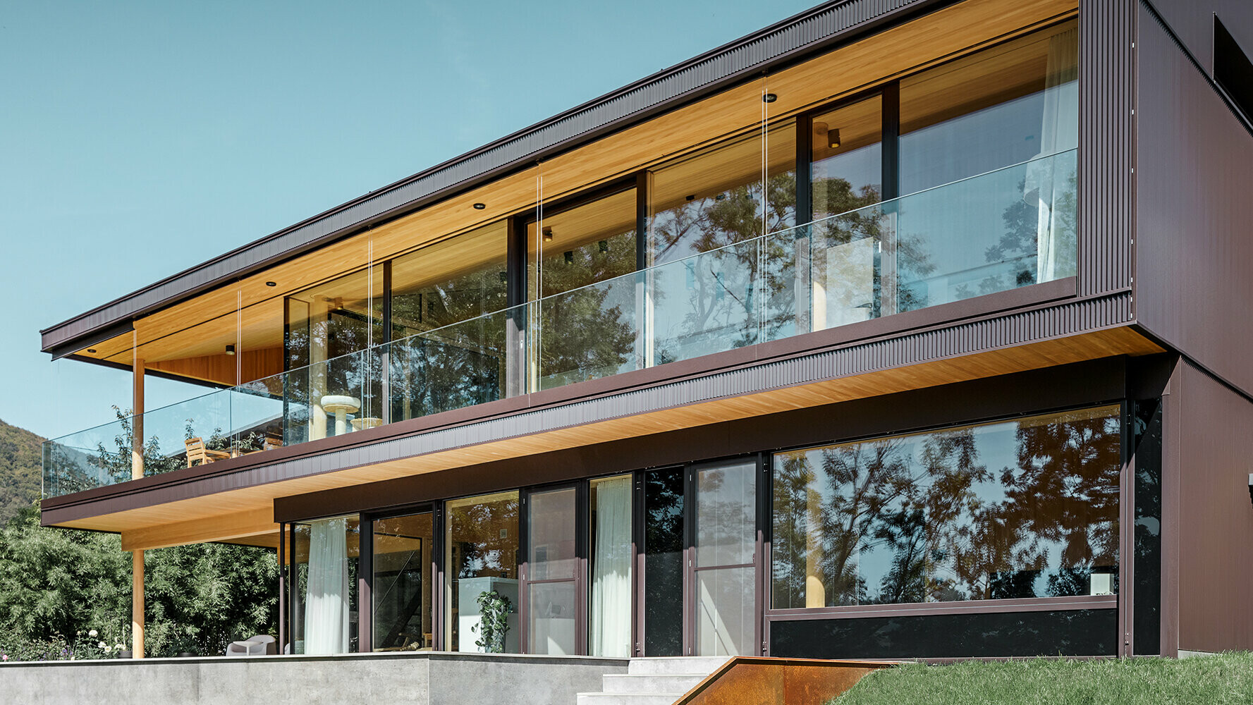 Nuova casa unifamiliare con ampie superfici in vetro e facciata in alluminio marrone