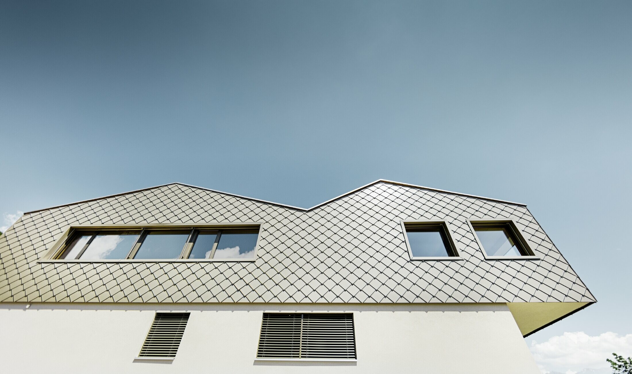 Modernes Einfamilienhaus mitten in den Weinbergen des Rhônetals mit 4 unterschiedlichen Dachflächen und offener Galerie mit einer Rautenfassade in bronze