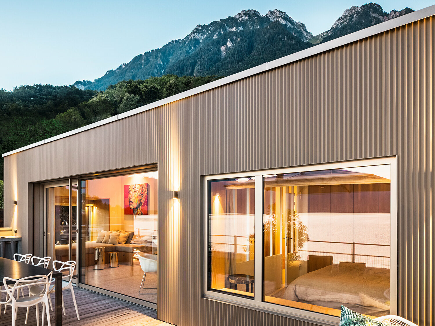 Vista della terrazza e di parte dell'interno dell'edificio di sera.