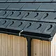Nahaufnahme der PREFA Dachplatte R.16 mit Schneestoppern, Dachrinne und Ablaufrohr in Schwarz P.10 inkl. Blitzschutz und einer senkrechten Holzfassade. Die robusten PREFA Aluminiumprodukte schmücken das Satteldach eines Einfamilienhauses in Lustenau, Vorarlberg.
