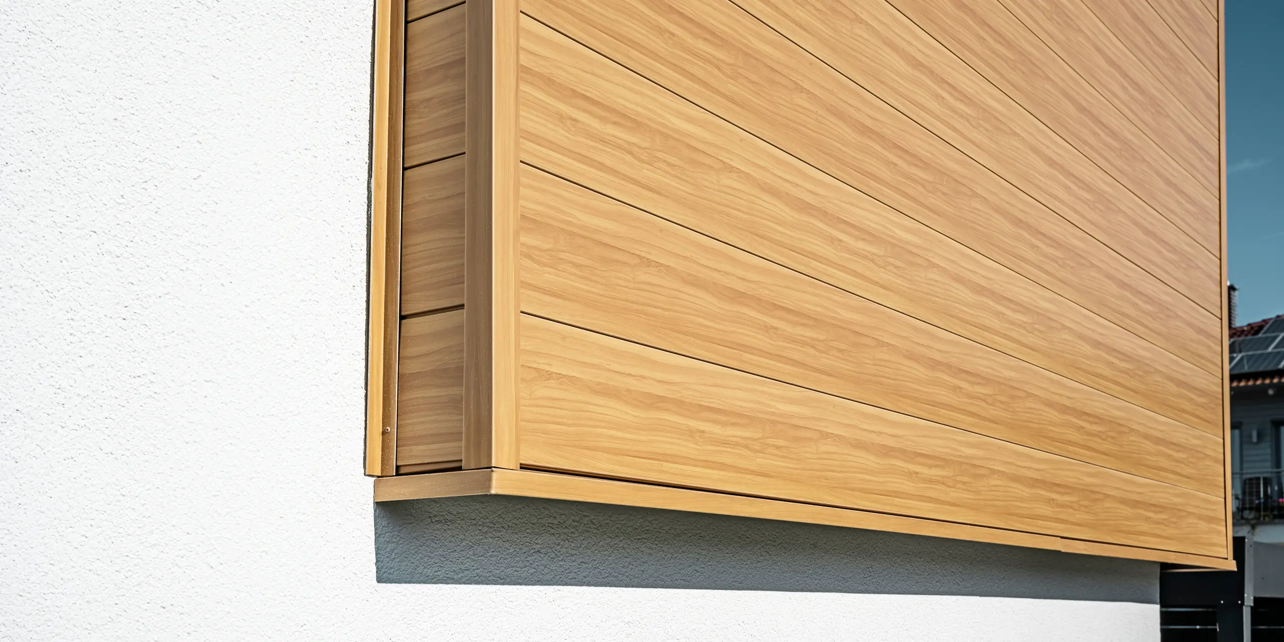 Primo piano della facciata in alluminio realizzata con rivestimenti PREFA Sidings nel colore rovere naturale su una casa unifamiliare a Usingen, Germania.