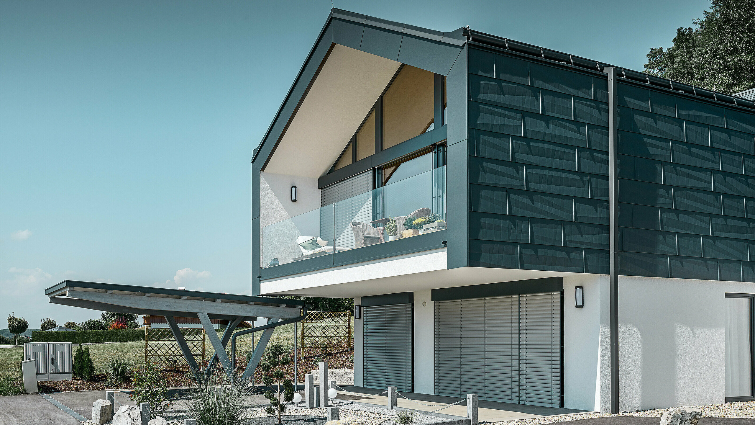 Obergeschoß mit FX.12 in P.10 Anthrazit Fassadenverkleidung des Obergeschoßes mit dem PREFA Fassadenpaneel FX.12 in P.10 Anthrazit. Als Ablaufrohr dient das robuste PREFA Quadratrohr.