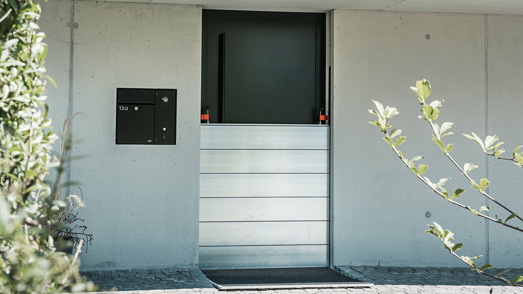 La barriera anti-esondazione di PREFA protegge i garage di una casa unifamiliare dalle alluvioni