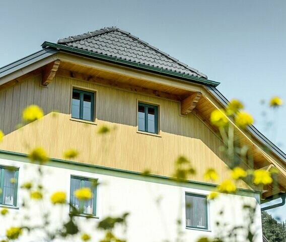 Giebelverkleidung mit den Alu Paneelen von PREFA in Holzoptik Eiche natur, verarbeitet sind die Sidings in vertikal inklusive Verkleidung der Dachuntersicht