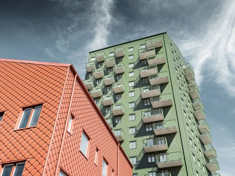 Ansicht von unten auf die neuen Wohnhäuser in Göteburg, die Fassade wurde eingedeckt mit PREFA Rauten in Erdfarben 