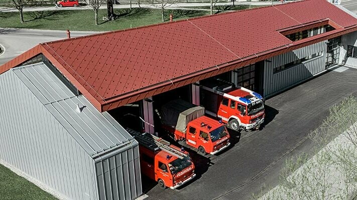 Feuerwehrhaus der Firma PREFA in Marktl mit rotem Rautendach und Stehfalzdach und -fassade in Silbermetallic. Mehr Infos zu den Brandklassen erhalten Sie hier.
