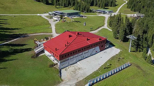 Rifugio e ristorante Summit Mountain Club in primavera circondato dai prati verdi. A 1.830 metri, vicino alla stazione a monte Rinneralm (2.100 m), il Summit Mountain Club si posiziona come nuovo punto di riferimento per gli appassionati di sport invernali e gli ospiti estivi e, sempre più, come luogo per eventi aziendali e riunioni.