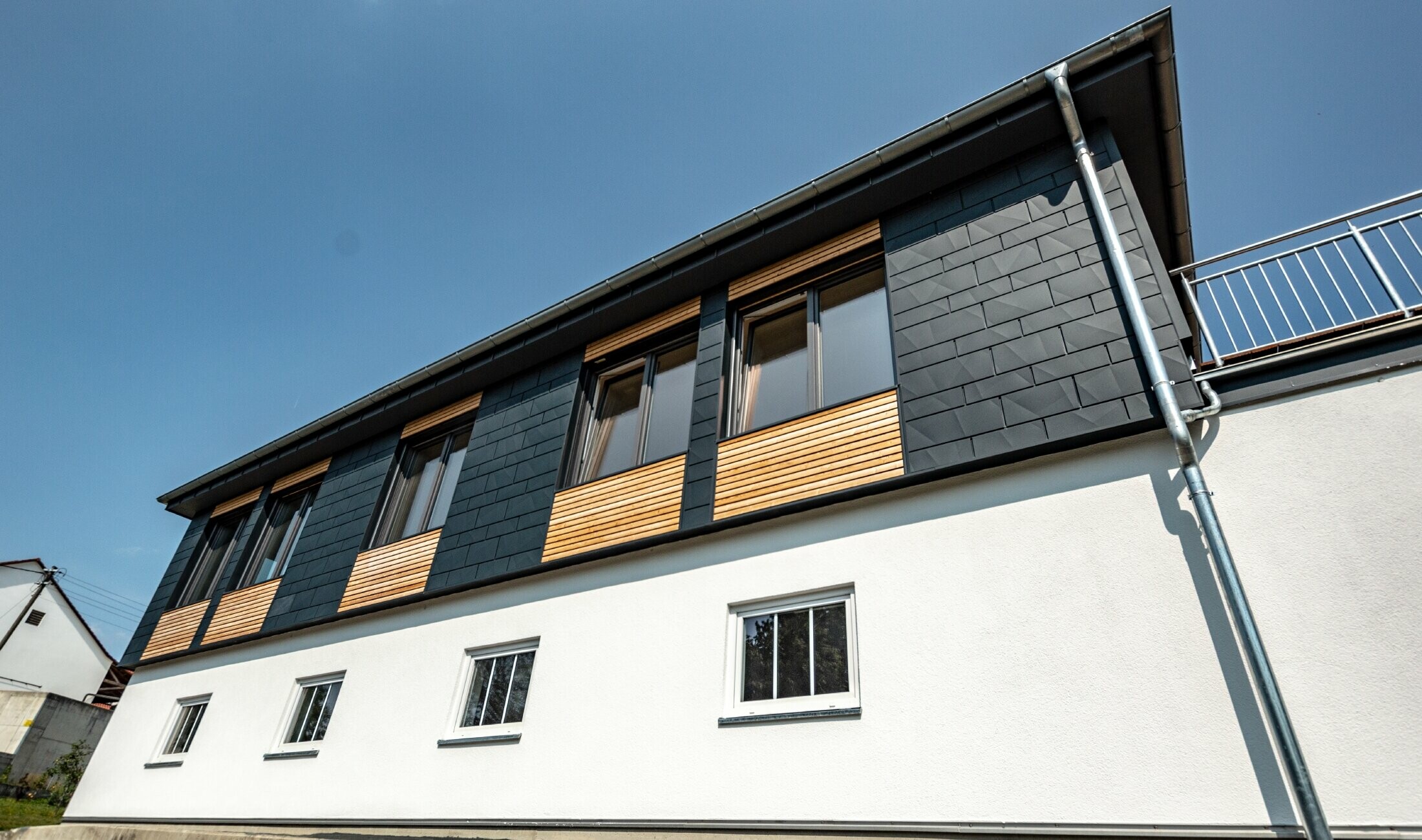 Fassadengestaltung mit unterschiedlichen Baustoffen: verwendet wurden Aluminium PREFA Siding.X in Anthrazit, eine horizontale Holzfassade und eine weiße Putzfassade.