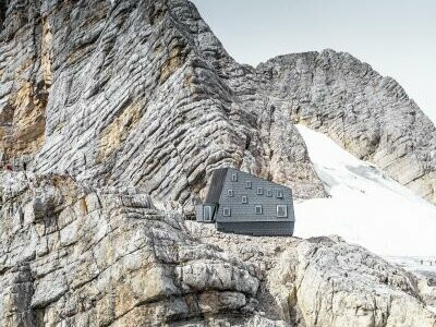 Il rifugio Seethalerhütte a 2.740 metri nel cuore del paesaggio roccioso del monte Dachstein, rivestito in copertura e facciata con i pannelli FX.12 PREFA P.10 grigio pietra