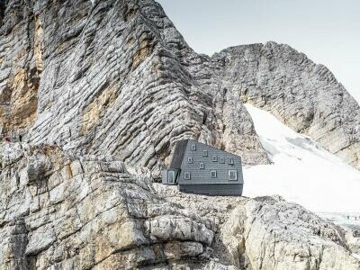 Il rifugio Seethalerhütte a 2.740 metri nel cuore del paesaggio roccioso del monte Dachstein, rivestito in copertura e facciata con i pannelli FX.12 PREFA P.10 grigio pietra