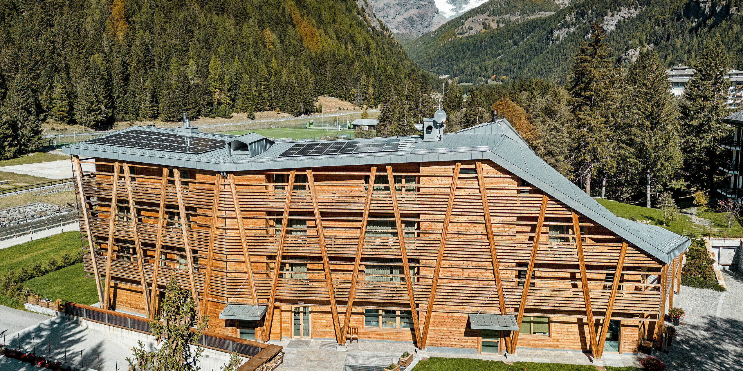 Luxus-Öko-Hotel Au Charmant Petit Lac in Champluc mit einem PREFALZ-Dach in P.10 Steingrau und einer Holzfassade..