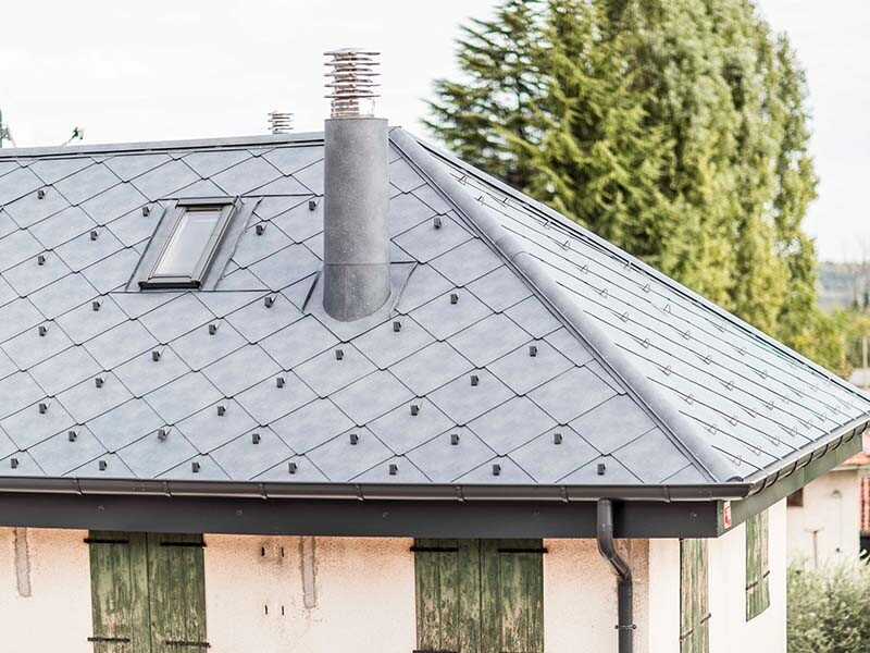 Condominio con copertura ristrutturata in scaglie 44 di PREFA nel colore P.10 grigio pietra a Valcellina