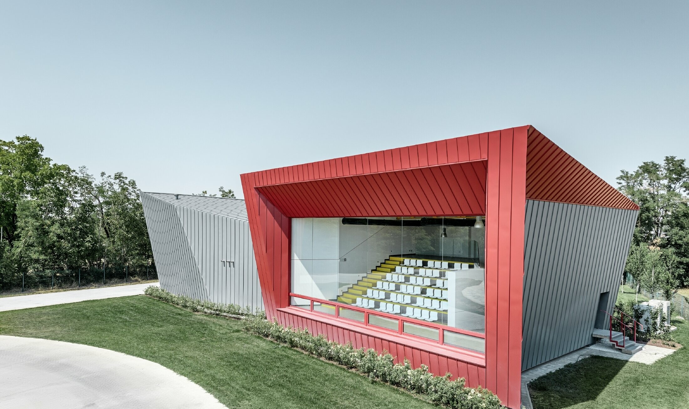 Centro allenamenti moderno di Dieci a Montecchio Emilia (Italia) con tribuna con facciata in alluminio Prefalz in grigio chiaro e Falzonal in karminrot.