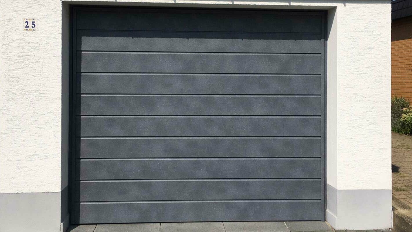 Portone del garage con doghe di rivestimento PREFA color grigio pietra in posa orizzontale