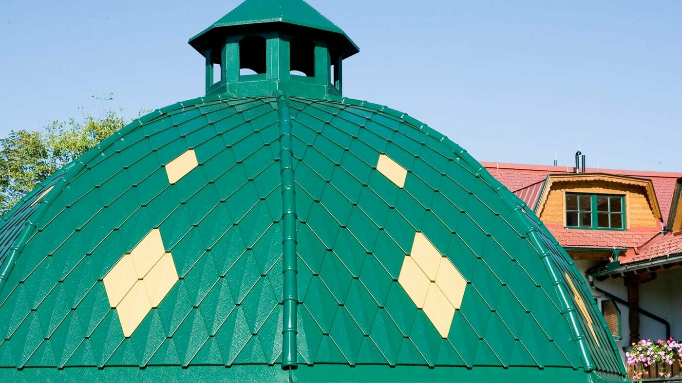 cupola tonda rivestita con le scaglie piccole PREFA nel colore verde muschio.