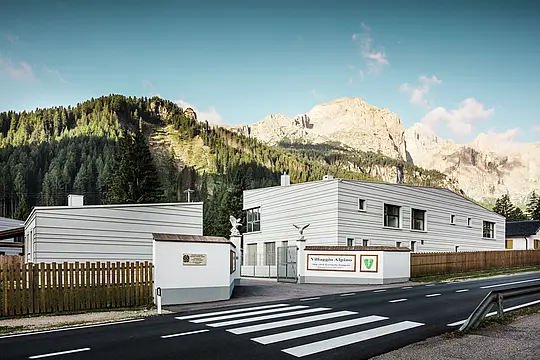 Davanti a un imponente scenario montano, i quattro nuovi edifici del centro logistico e di addestramento “Villaggio Alpino Tempesti” combinano il paesaggio alpino con l'architettura moderna. Le lastre in alluminio PREFALZ posate con precisione nel colore P.10 bianco PREFA garantiscono linee pulite, elevata resistenza e vantaggi climatici. Sono una dichiarazione di design funzionale nel cuore dell'Alto Adige. Davanti alla strada di accesso alla moderna caserma si trova una strada con strisce pedonali.
