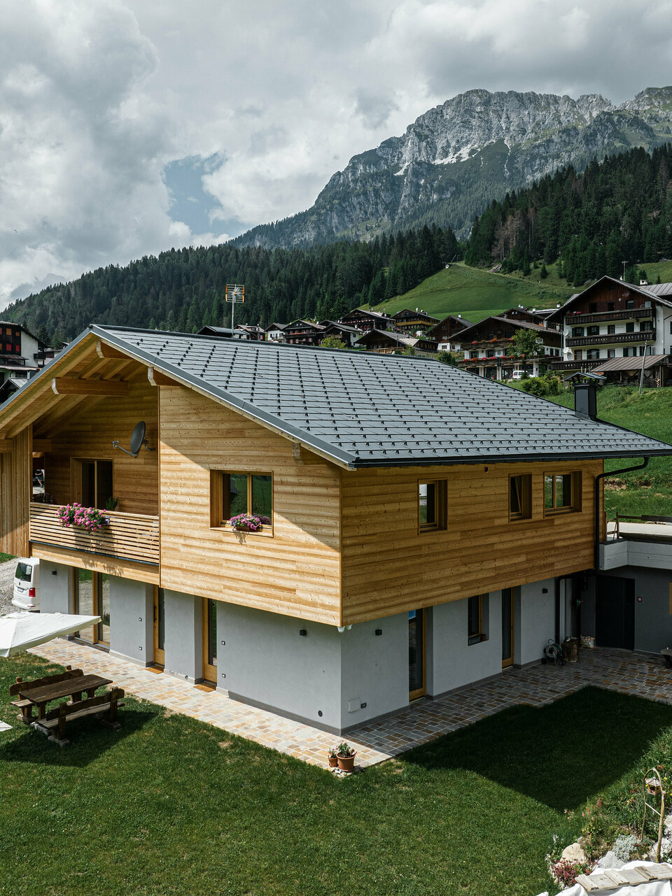 Das Einfamilienhaus Casa Hoffe in der alpinen Gemeinde Sappada, Italien, zeigt ein harmonisches Zusammenspiel von traditioneller und moderner Architektur. Ausgestattet mit PREFA Dachplatten R.16 in P.10 Schwarz, die Stabilität und Eleganz verleihen, während die Siding.X Fassadenpaneele im Eingangsbereich das Design mit einer extravaganten Note bereichern. Die langlebigen Aluminiumelemente von PREFA integrieren sich nahtlos in die für die Region typische Holzfassade und bieten dauerhaften Schutz inmitten der idyllischen Berglandschaft.