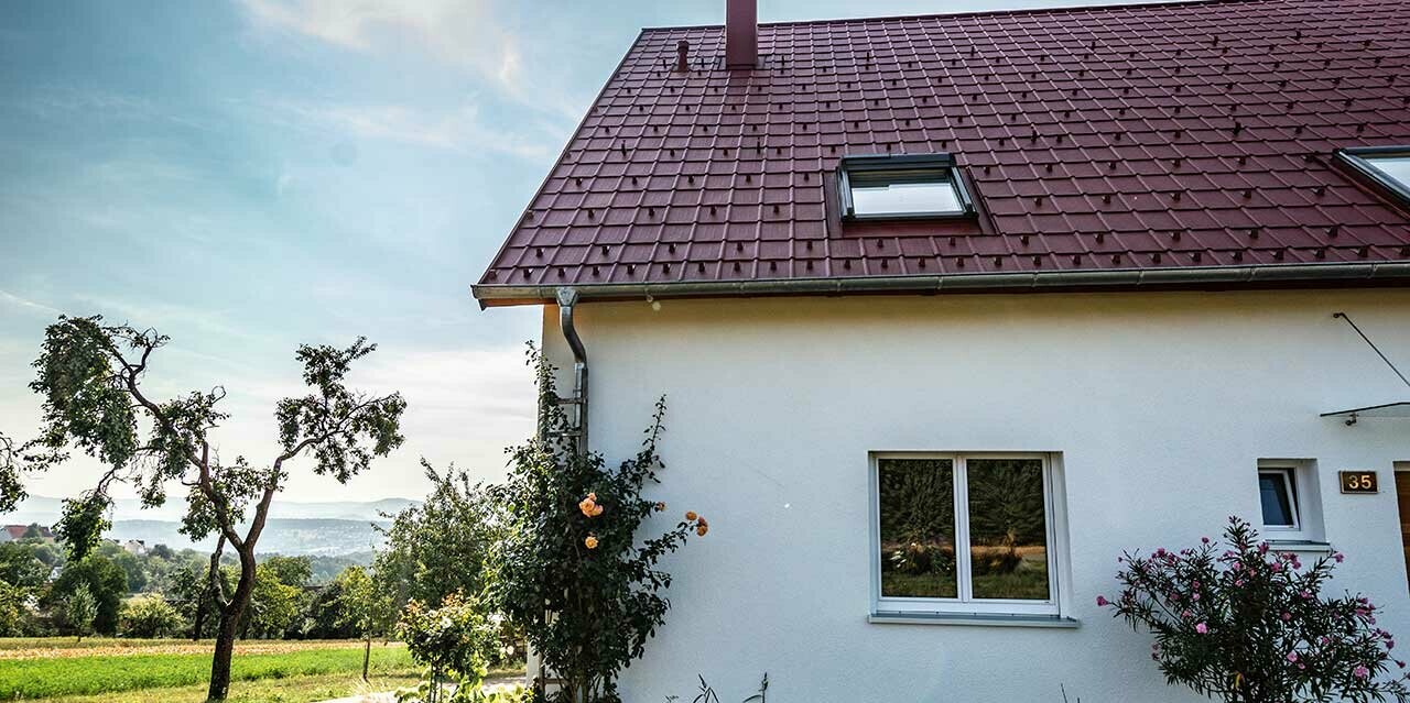 Häuschen am Land, neu saniertes Dach mit PREFA Dachplatte in Oxydrot, Dachfenster und Kamineinfassung.