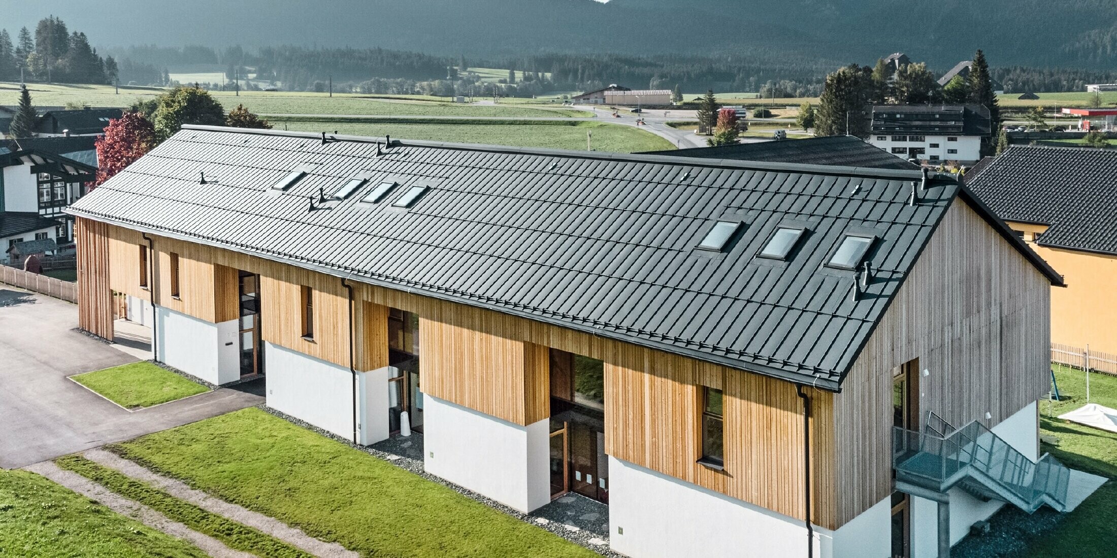 Kräuterkindergarten in Bad Mitterndorf mit großem PREFALZ Dach in P.10 Anthrazit und Holzfassade