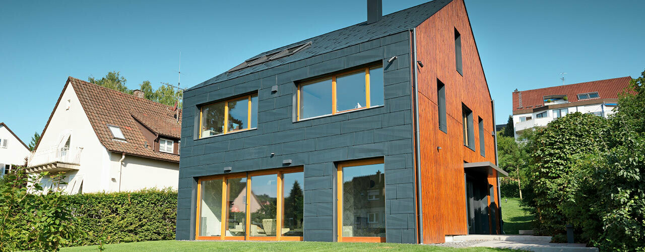 Die PREFA FX.12 Fassade in P.10 Anthrazit zieht sich von der Fassade über das Satteldach, ganz ohne Dachvorsprung.