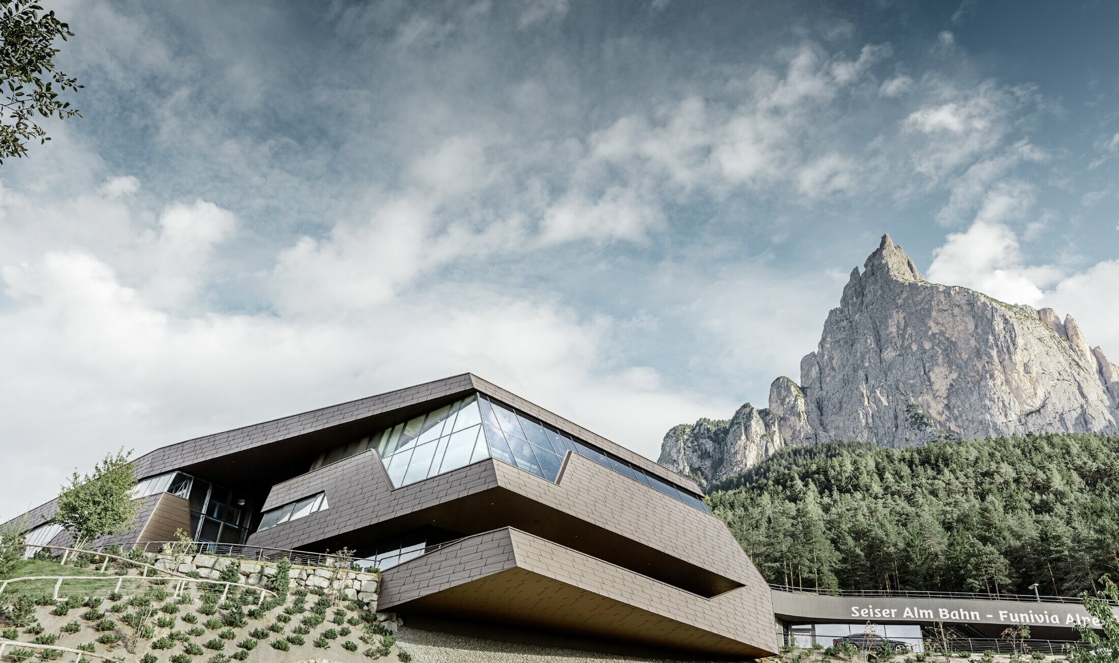 neu gestaltete Talstation der Umlaufbahn Seiser Alm, ähnlich der Dolomiten im Hintergrund mit unregelmäßigen Kanten und Oberflächen mit einer Aluminium Fassade in braun von PREFA