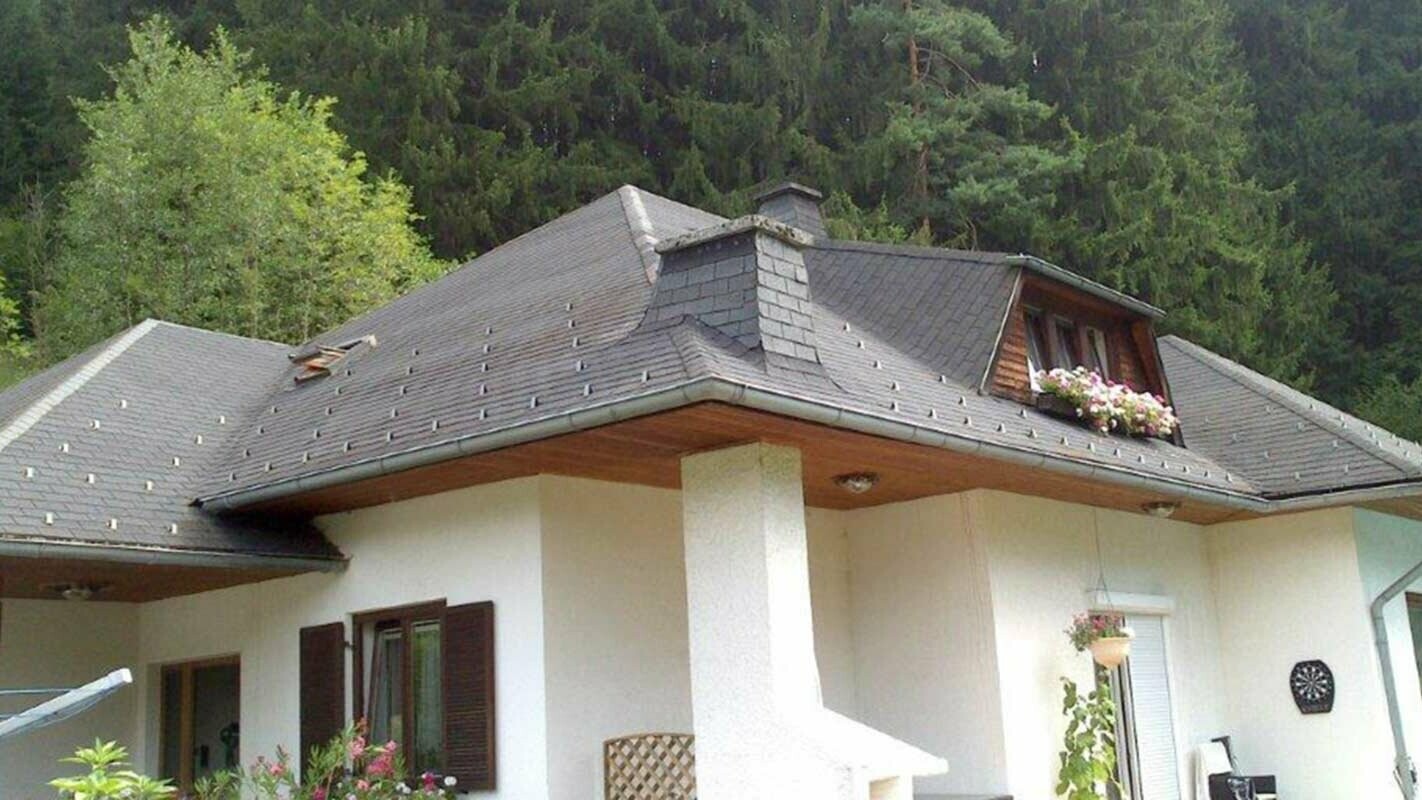 Casa monofamiliare con tetto a padiglione prima della ristrutturazione del tetto con tegole PREFA, incluso abbaino trapezoidale
