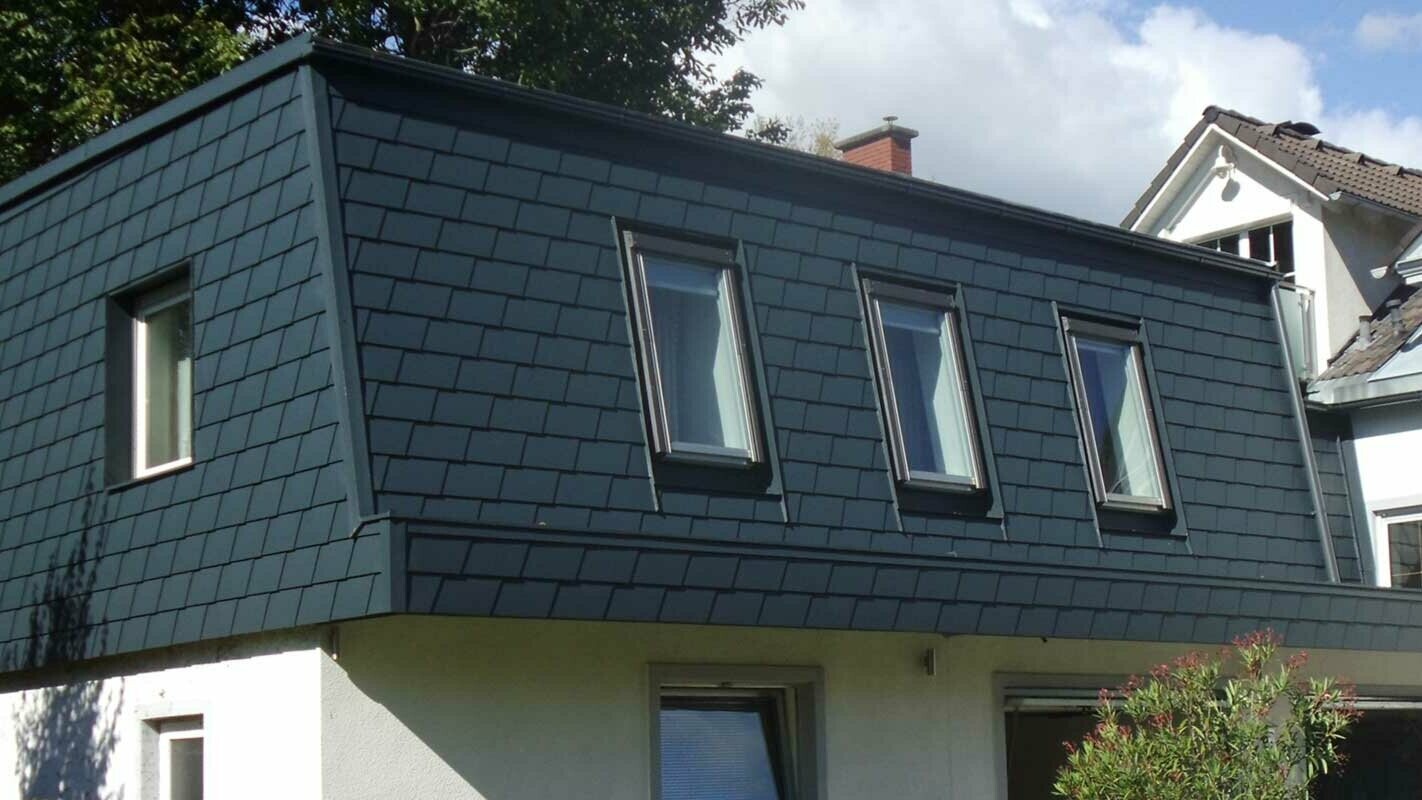 Copertura del tetto con scandole PREFA, moderna sopraelevazione color antracite con molte finestre