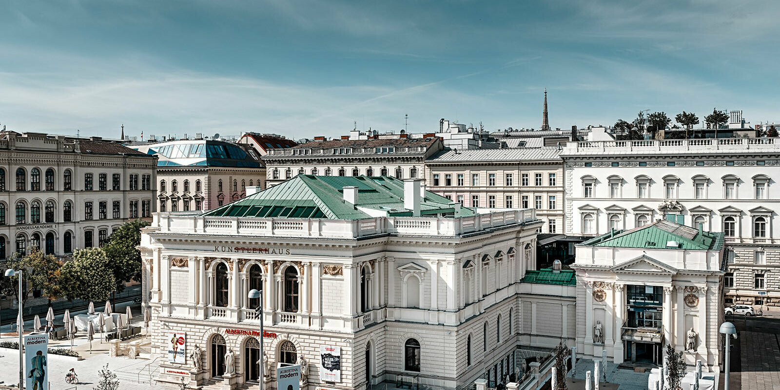 Es ist das Künstlerhaus in Wien zu sehen, umgeben von anderen Gebäuden.