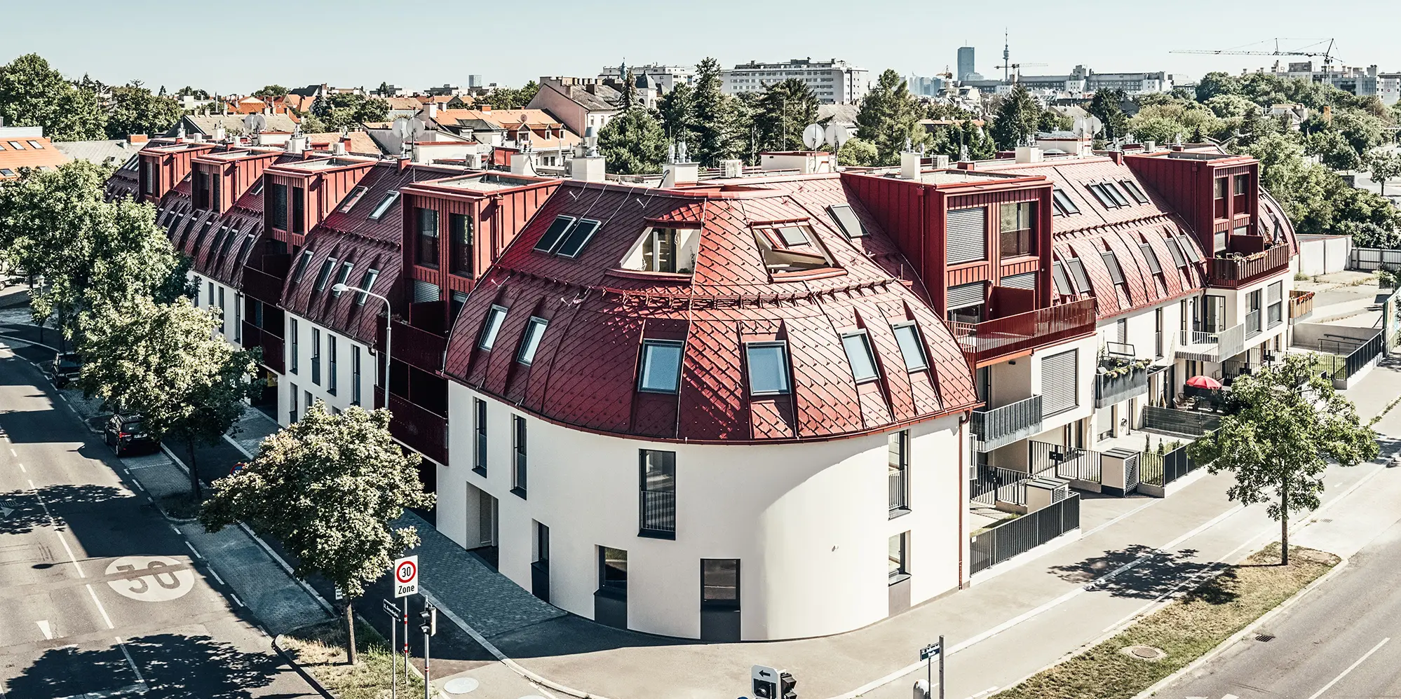 Vista dalla strada del complesso residenziale Schöneck 13 e del tetto arrotondato, progettato dallo studio di architettura schneider+schumacher.