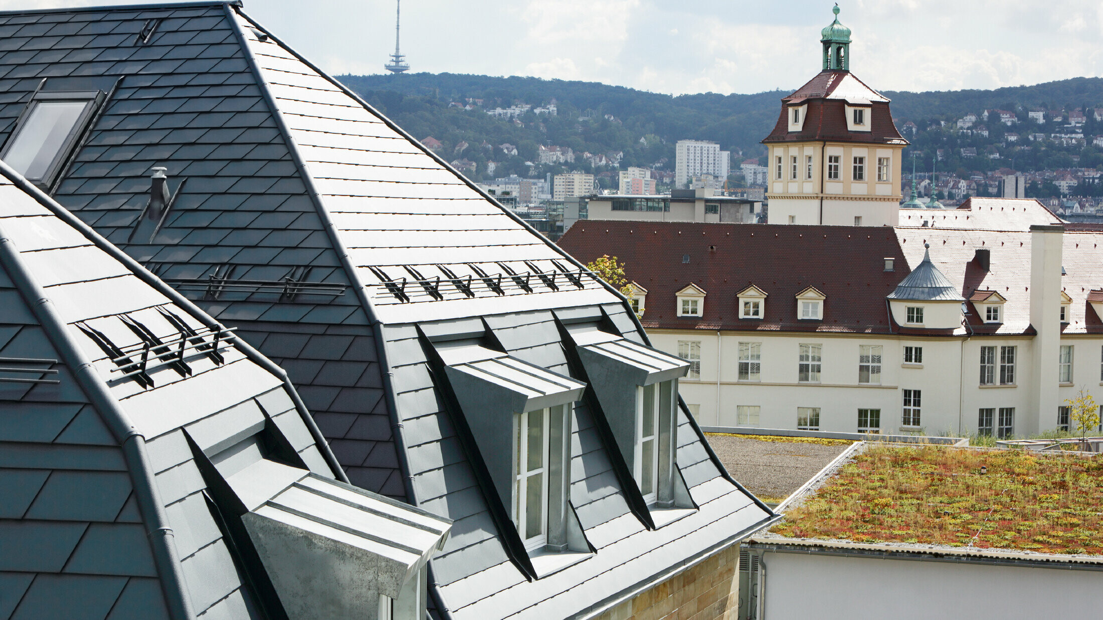 Vecchio Stadthaus (palazzo comunale) di Stoccarda con tetto a falde e numerosi abbaini, ricoperto con scandole di alluminio PREFA in P.10 antracite