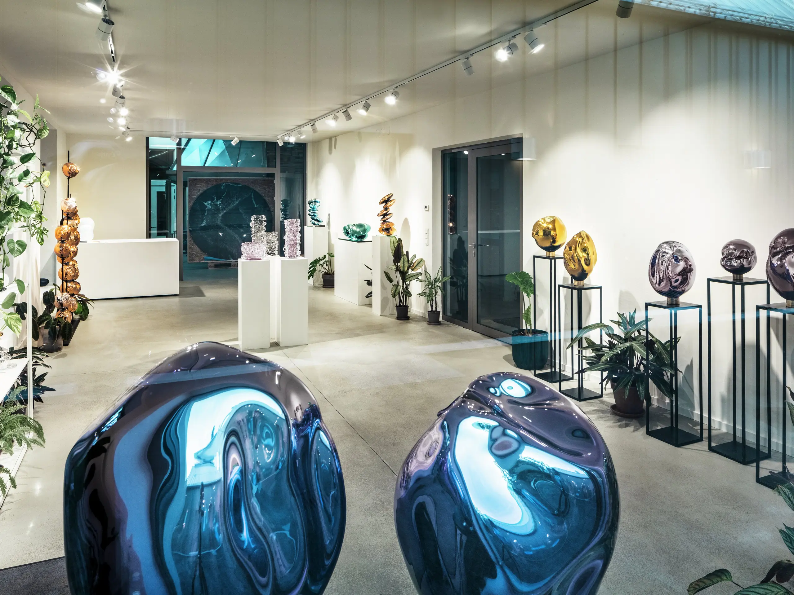 Vista interna dello Studio Comploj di Vienna con una mostra di oggetti in vetro fatti a mano. Il moderno spazio della galleria combina arte, design e artigianato in un ambiente elegante.