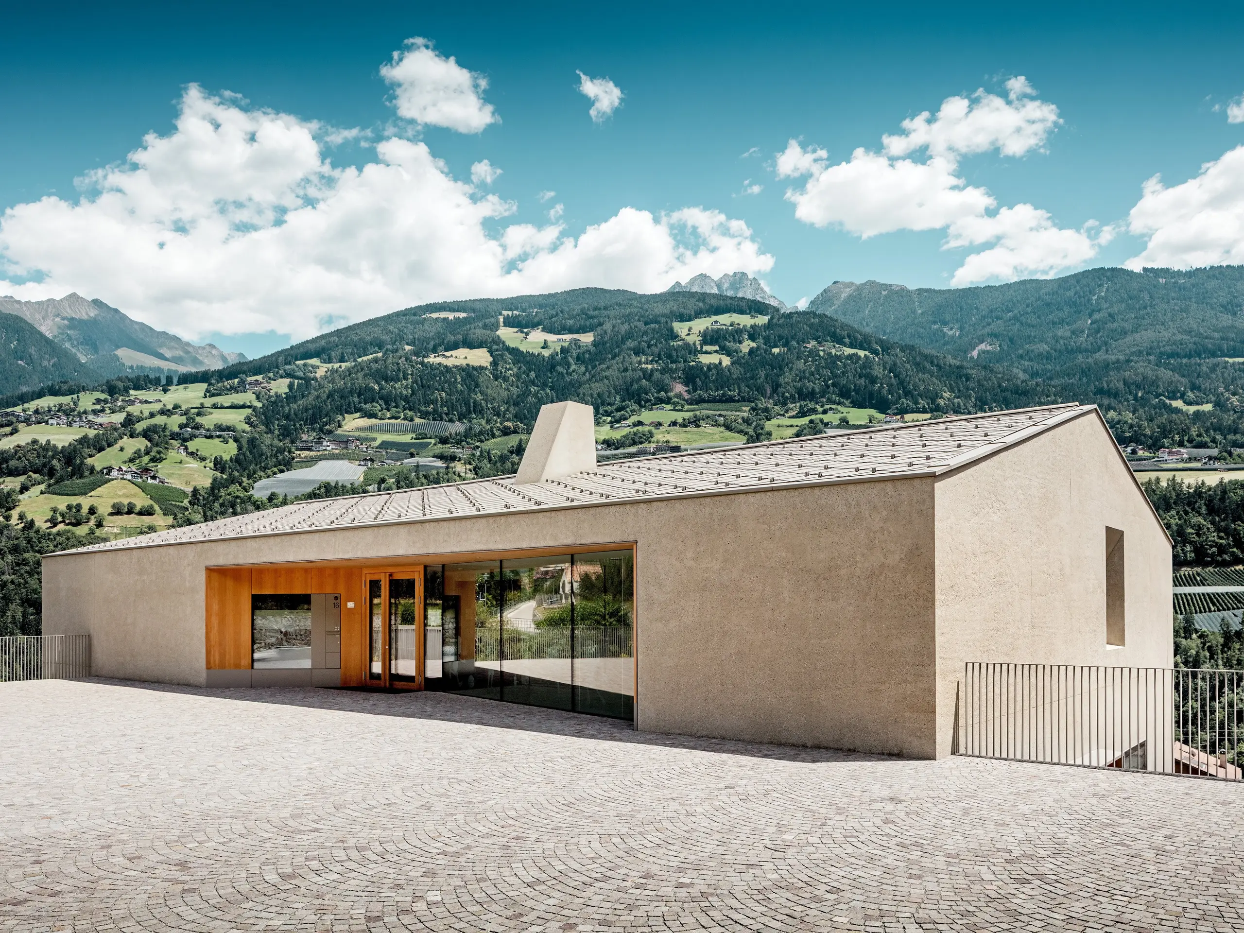 Il centro educativo di Riffian, in Alto Adige, si inserisce armoniosamente nel paesaggio montano grazie alla sua architettura lineare. Il tetto PREFA con scaglie 44 × 44 in P.10 bronze convince per la lavorazione precisa dell’alluminio, l’elevata resistenza agli agenti atmosferici e la protezione duratura: una rifinitura elegante per la scuola materna e la scuola elementare.
