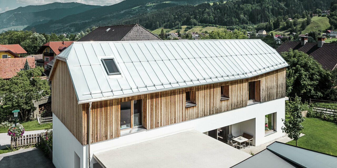 Seitliche Ansicht des modernen Einfamilienhauses im schönen Ort Pruggern. Das Dach wurde mit PREFALZ in der Farbe Naturblank eingedeckt.