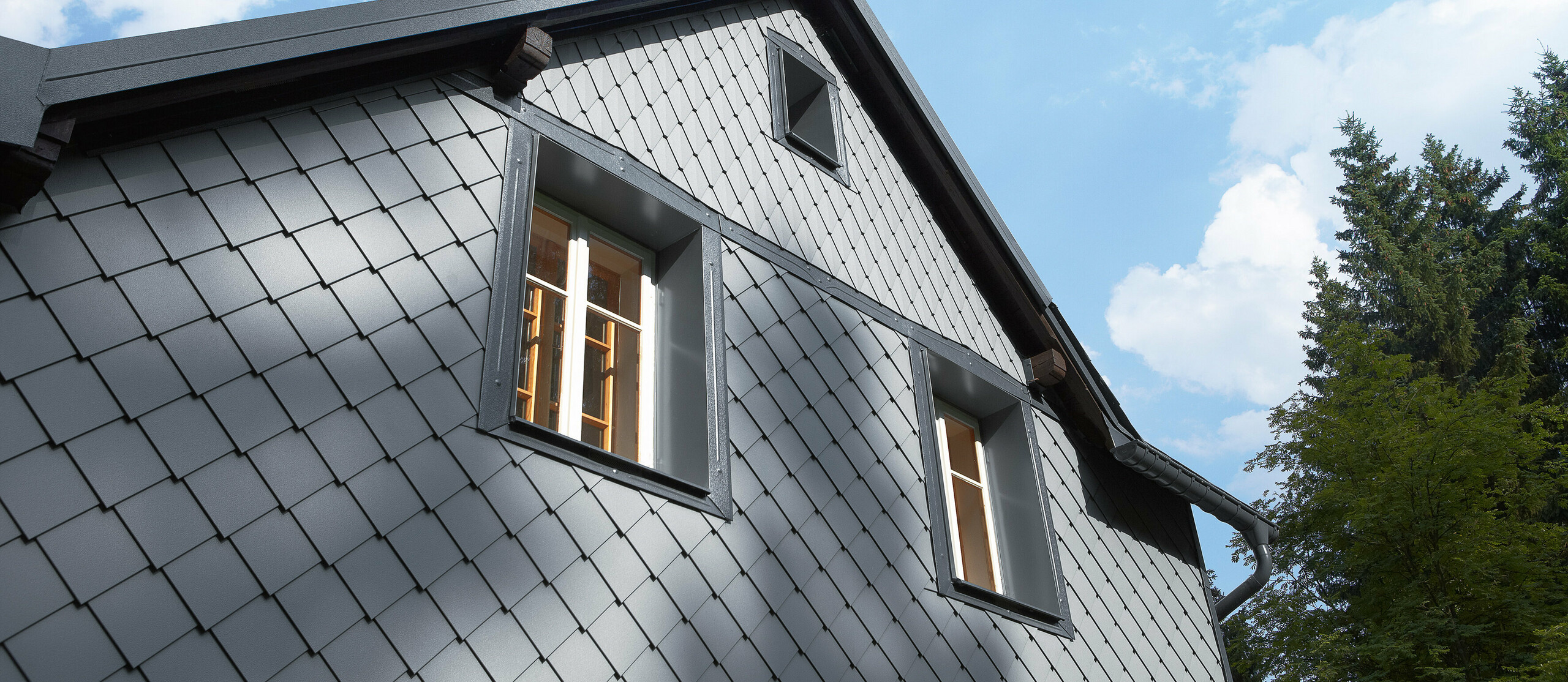 Wetterseite verkleidet mit der Wandraute 20 × 20 und der kleinen Raute an der Fassade von PREFA