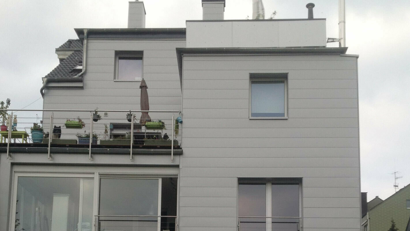 Condominio con tetto piatto e terrazzo con la nuova facciata ristrutturata con doghe di rivestimento PREFA