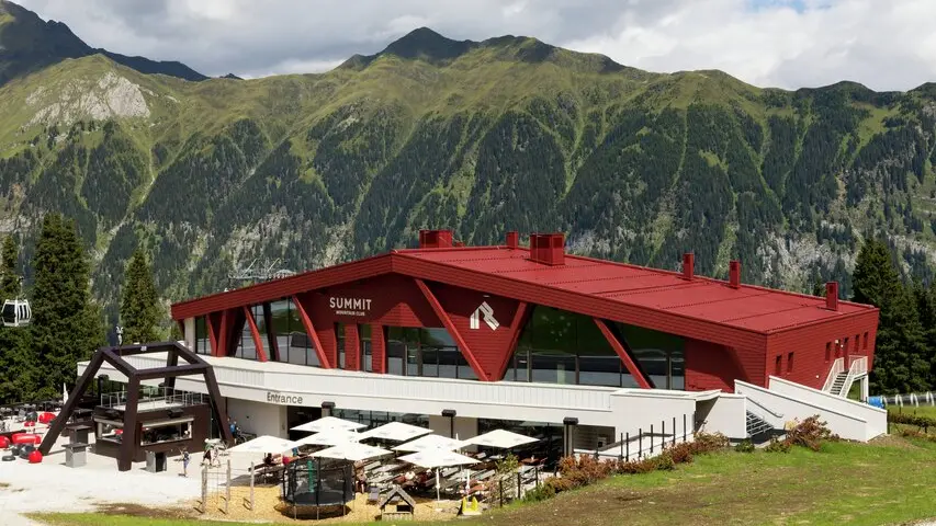 Rifugio e ristorante Summit Mountain Club in primavera circondato dai prati verdi. A 1.830 metri, vicino alla stazione a monte Rinneralm (2.100 m), il Summit Mountain Club si posiziona come nuovo punto di riferimento per gli appassionati di sport invernali e gli ospiti estivi e, sempre più, come luogo per eventi aziendali e riunioni.
