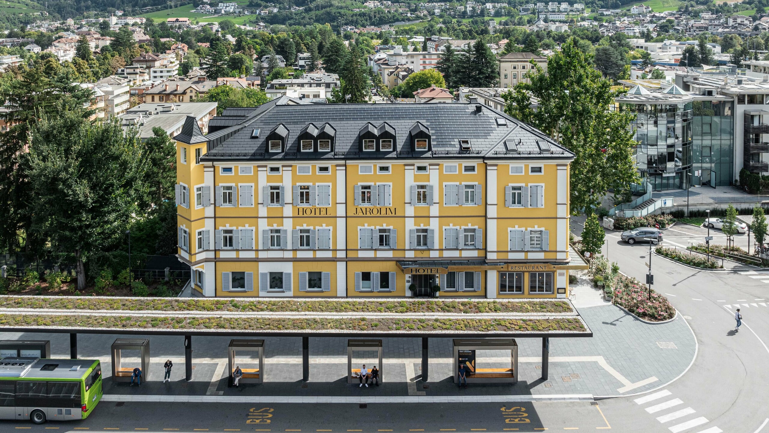 Vista dall'alto dello storico Hotel Jarolim ristrutturato in tegole fotovoltaiche PREFA a Bressanone.