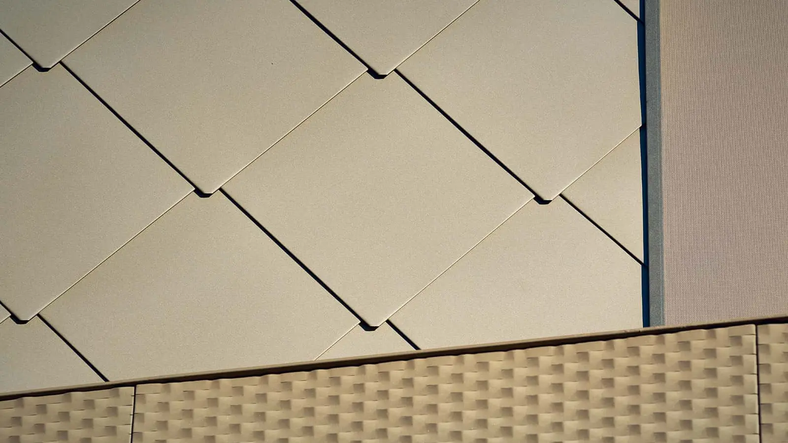 L'immagine mostra un primo piano delle scaglie per facciata PREFA 44 x 44 con lo speciale colore P.10 Bronze..