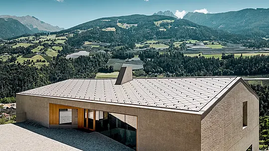 Il centro educativo di Riffian, in Alto Adige, presenta un’architettura moderna con scaglie 44 × 44 PREFA nella finitura P.10 bronze. La resistente copertura in alluminio si integra armoniosamente nel paesaggio montano, convince per la precisione della lavorazione e protegge in modo duraturo la scuola materna e la scuola elementare dagli agenti atmosferici.