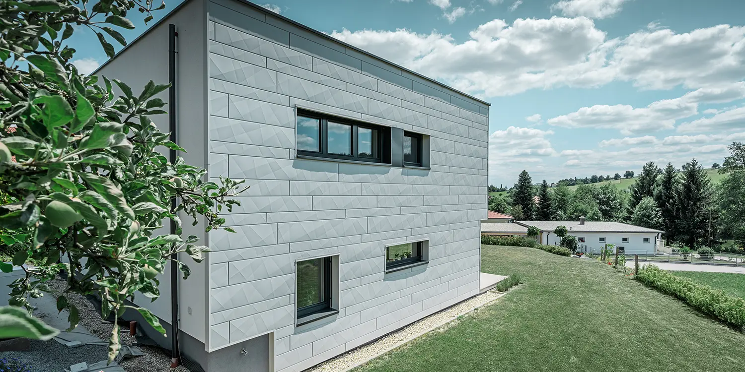 Vista laterale di una moderna casa unifamiliare con vista sulla facciata Siding.X.