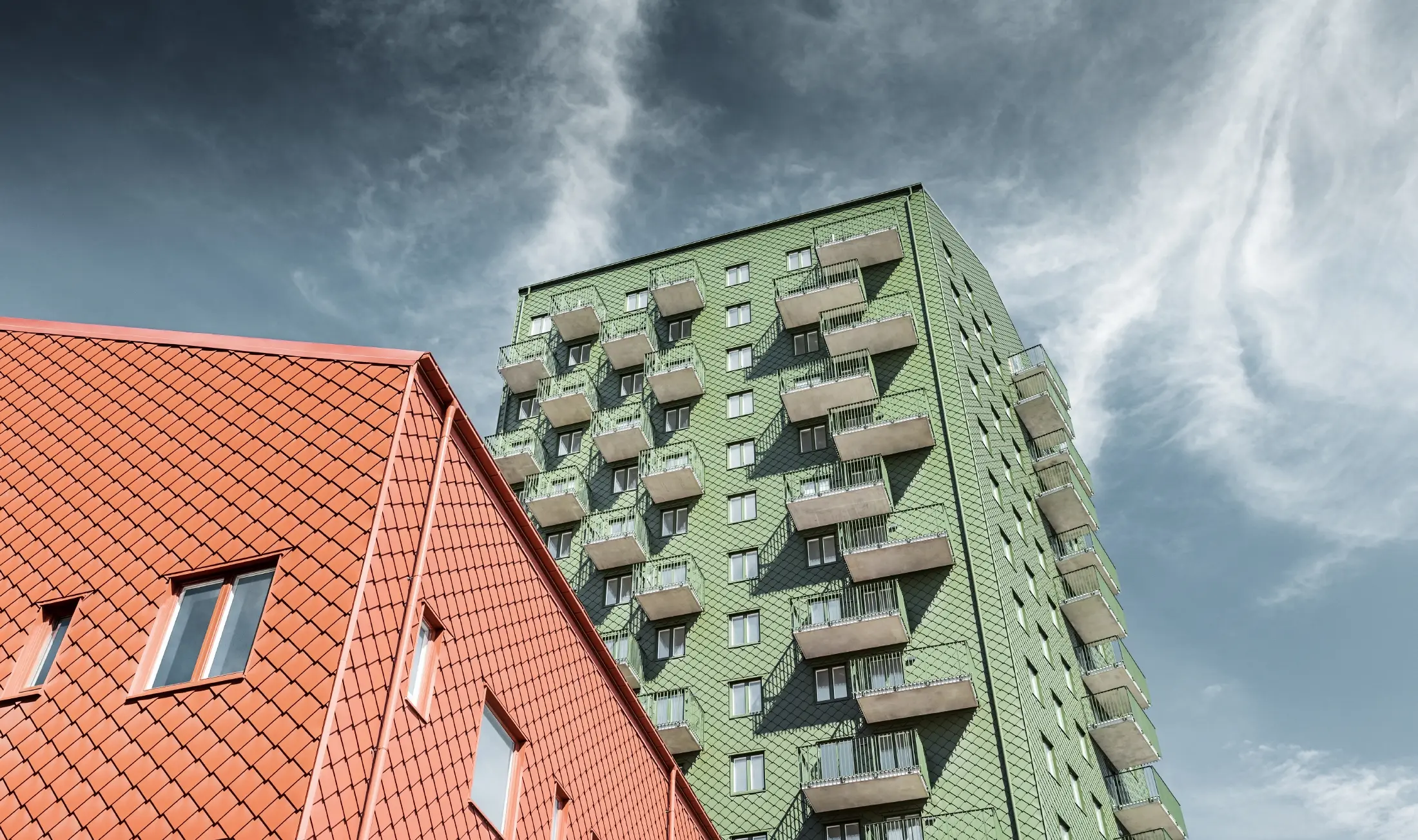 Edifici con balconi e design della facciata con scaglie PREFA 29 × 29 in verde oliva e rosso cotto